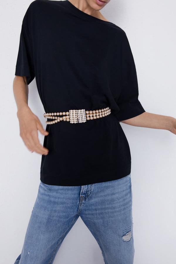 Cinturón metálico con aplicación de perlas y brillos y cierre con gancho metálico (Zara, 19,95 euros).