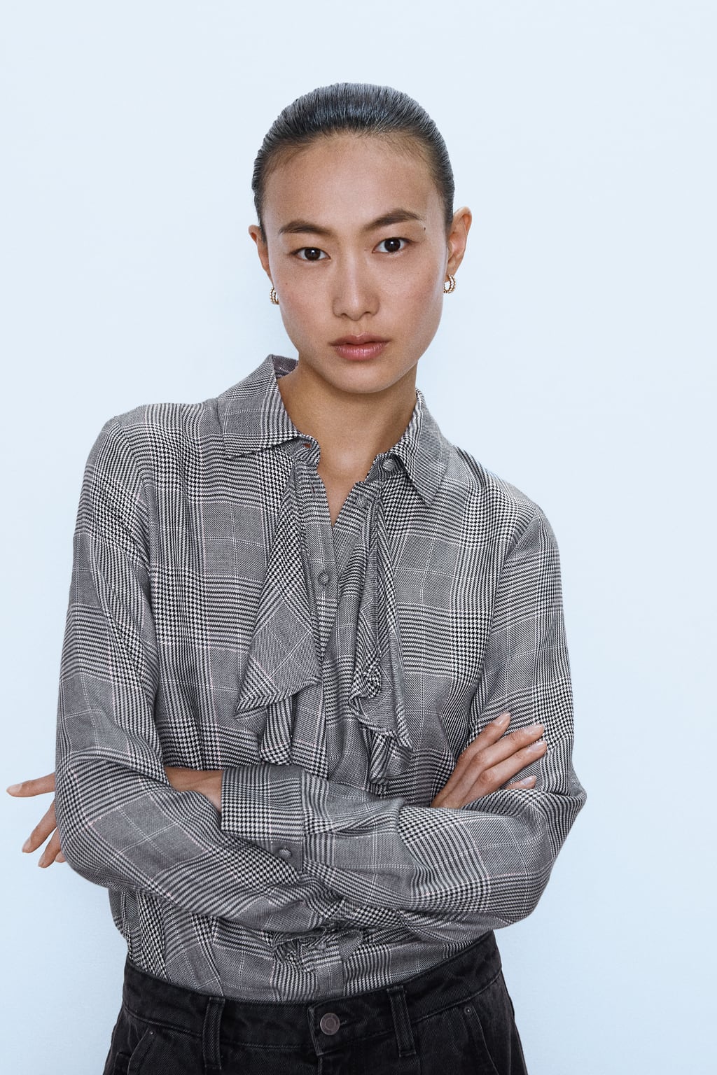 Blusa con volantes en tono gris. (25,95 euros).