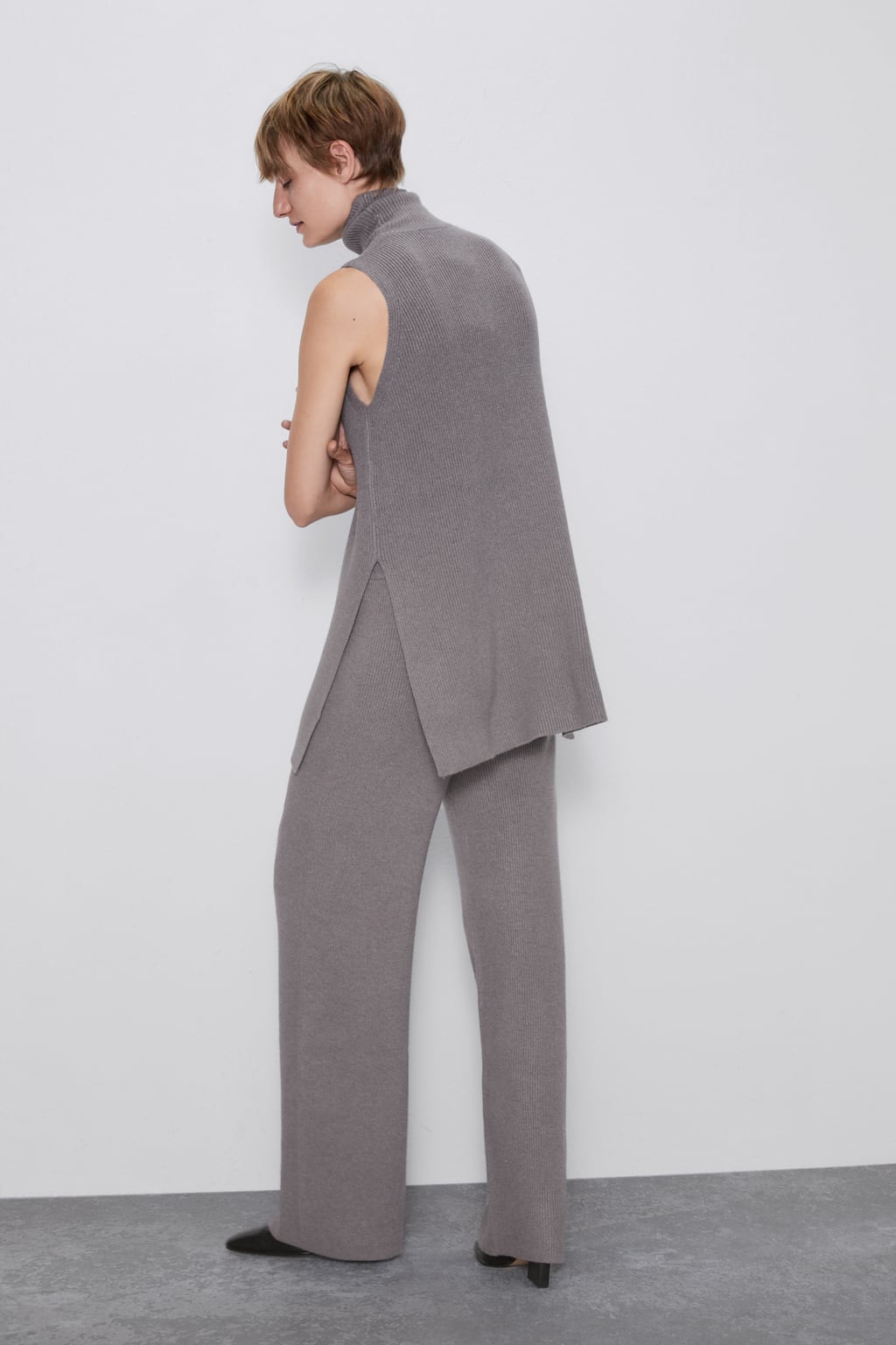 Conjunto de jersey (25,95 euros) con cuello y manga corta, y pantalones fluidos (29,95 euros) en tono gris. De Zara.