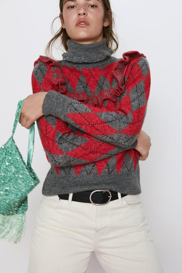 Jersey de punto con cuello subido y manga larga, con un clásico dibujo de rombos. va adornado con un volante en el mismo tejido (Zara, 29,95 euros).