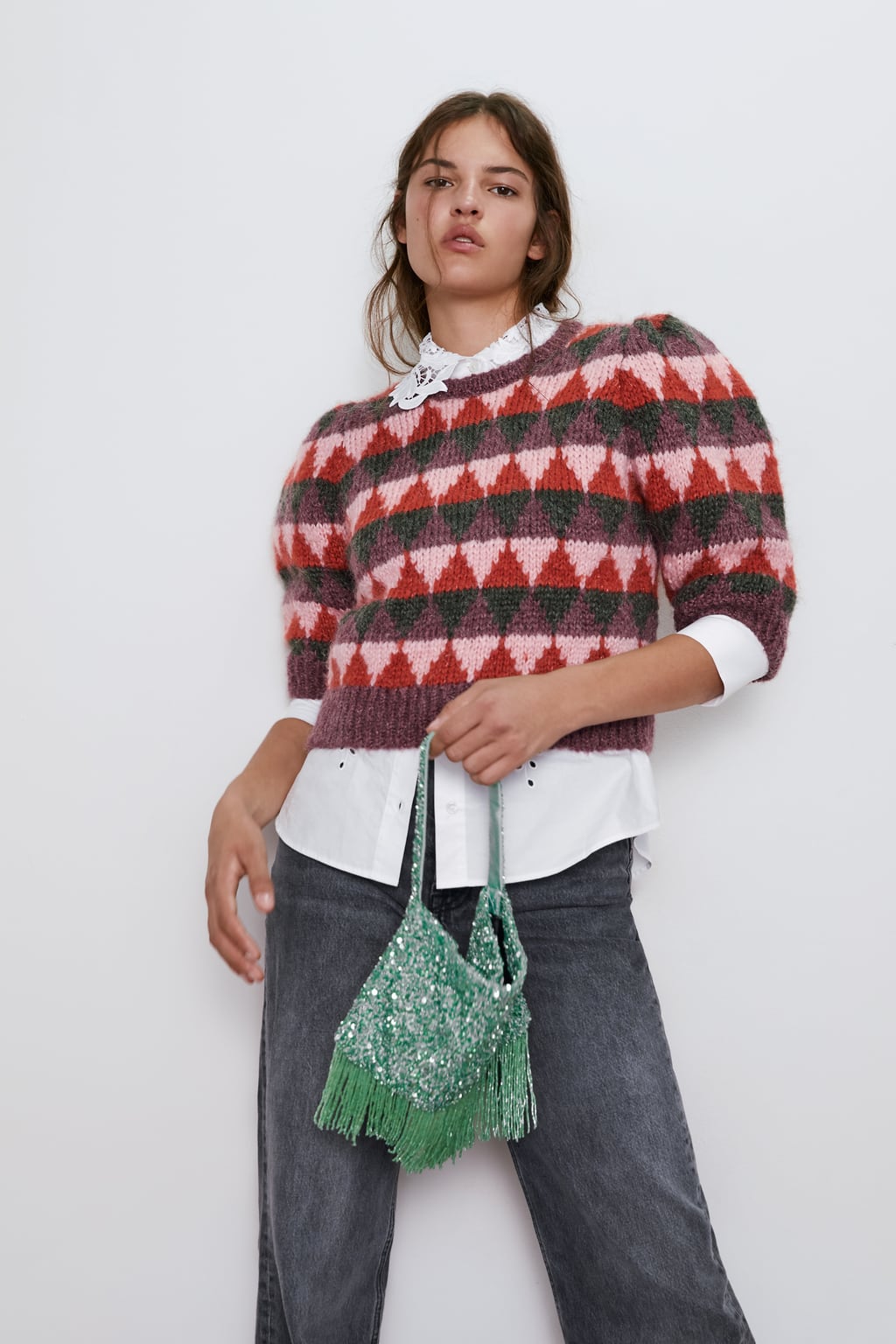 Ya se lo hemos visto a las influencers y falta muy poco para que se haga viral. Toma nota: jersey corto con estampado de rombos y manga abullonada (25,95 euros).