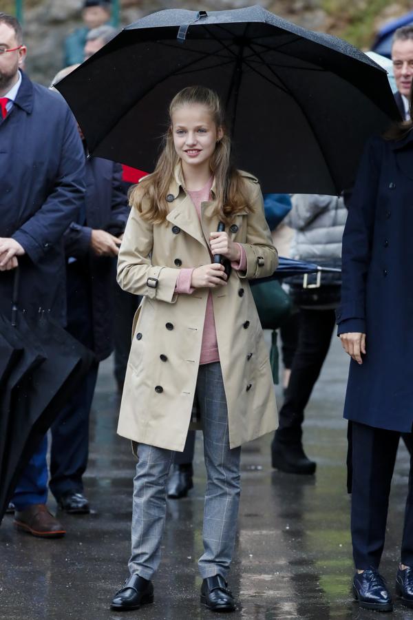 Como es tradición, la Princesa Leonor ha acompañado a sus padres, los Reyes, a visitar el pueblo que ha sido galardonado con el premio Pueblo Ejemplar de Asturias 2019. El municipio afortunado ha sido Asiegu, en Cabrales, pero el tiempo no ha respetado el gran día y la lluvia ha hecho que Leonor optara por un look de gabardina. Un modelo clásico en beige con botones negros y cinturón. Debajo, ha llevado unos pantalones de cuadros y un jersey rosa palo, todo acompañado de unos zapatos cerarados de hebilla lateral, perfectos para la lluvia.