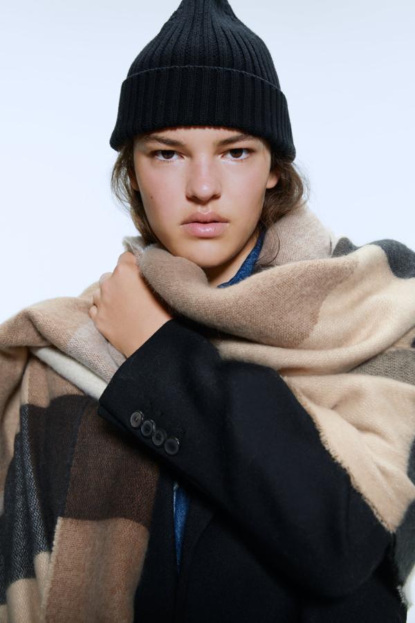 Si lo tuyo son las bufandas maxi y te gusta estar bien cubierta sin renunciar a un par de vueltas alrededor del cuello, esta es tu bufanda. Tejida en cuadros con acabado desflecado, cuesta 19,95 euros y es de Zara.