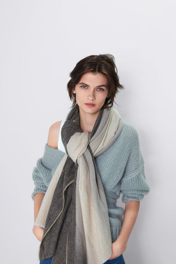 El beige y el azul marino se unen en este pañuelo degradado con acabados desflecados de Zara. Ideal para los estilismos más desenfadados, cuesta 19,95 euros.