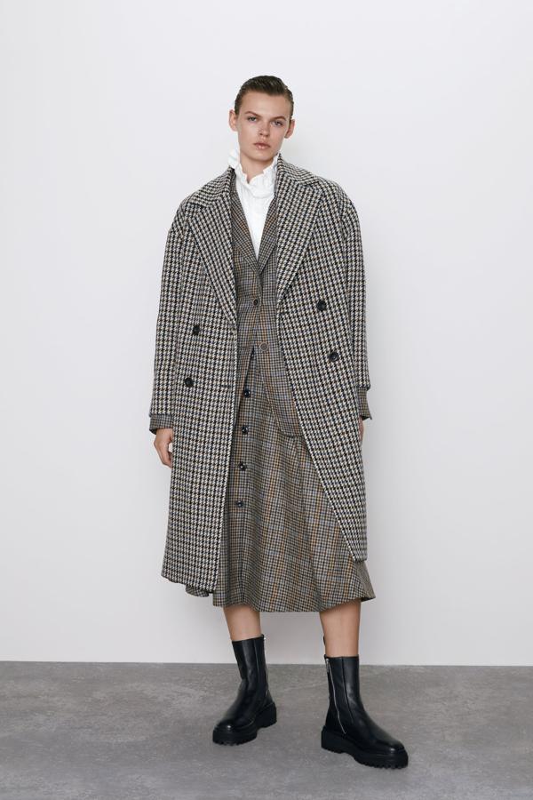 Abrigo tipo inglés, de cuadros en tonos azules y grises, con vuelo y detalle de trabilla en la espalda, de Zara (89,95 euros). Para las que están buscando algo diferente.