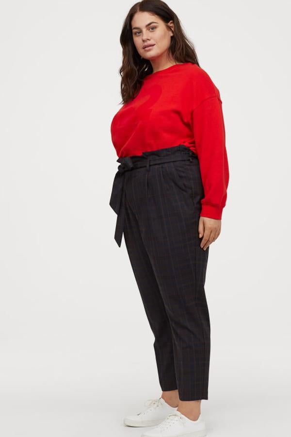 También en H&M, una preciosa combinación de pantalonescon un estampado de cuadros en azul y rojo, talle alto con pinzas, cierre de cremallera con corchete oculto, bolsillos al bies, cinturón de anudar extraíble y perneras pitillo con raya (24,99 euros). Sudadera corta con motivo afelpado, de corte cuadrado con escote amplio, hombros caídos y remate en punto elástico en puños y bajo (19,99 euros). Y zapatillas deportivas blancas (19,99 euros).