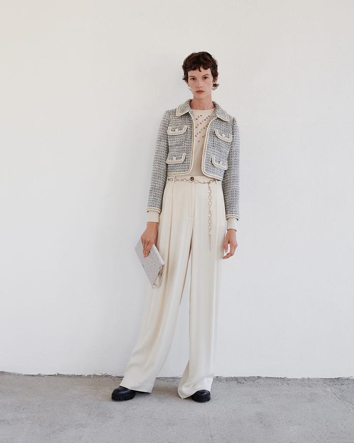 Este look de Uterqüe parece sacado de los archivos de Mademoiselle Chanel, con su icónica 'petite veste noire' (la versión de Inditex cuesta 159 euros) y sus maxi pantalones palazzo (79 euros).