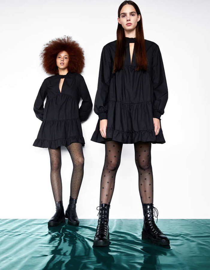 Vestido corto de popelín con cuello alto de goma canilla y abertura en el escote (Bershka, 25,99 euros). Lleva manga larga con volumen y bajo con volantes. A los pies, botines acordonados con plataforma y suela track (Bershka, 39,99 euros) y botines de piel con cremallera frontal y pllataforma con suela track (Bershka, 55,99 euros).
