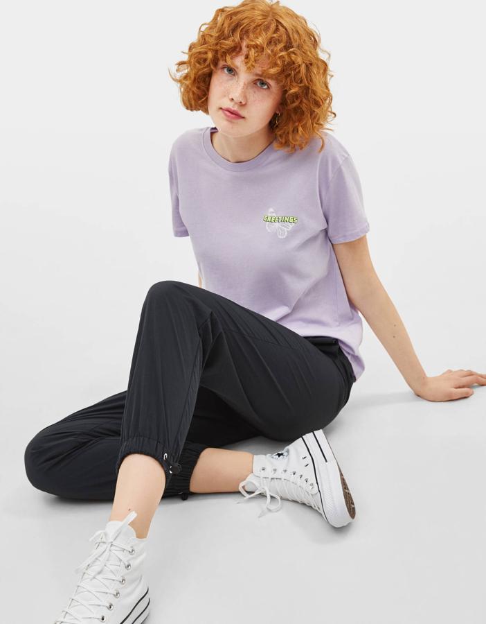 En tono lila y con letras en contraste a la altura del pecho, sobre un estampado en forma de mariposa. Si lo tuyo son los tonos pastel, esta puede ser la camiseta que estabas buscando.