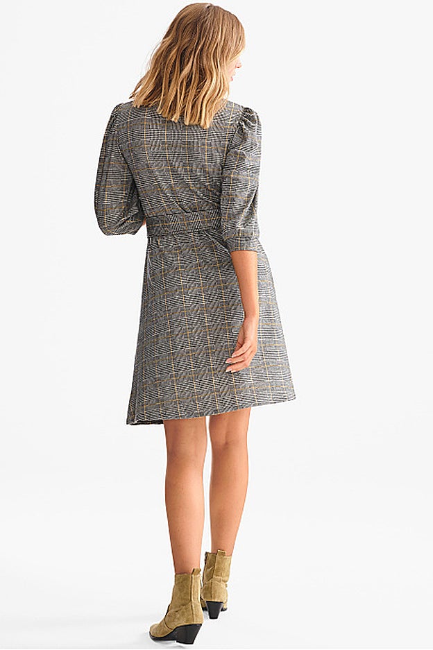 El cinturón entalla la prenda, que queda por encima de la rodilla.