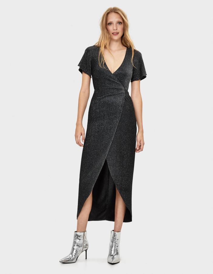 No todo van a ser opciones mini. Aquí tienes un vestido largo (también con su toque sexy en la abertura) en negro con tejido de purpurina que nos ha enamorado (35,99 euros).