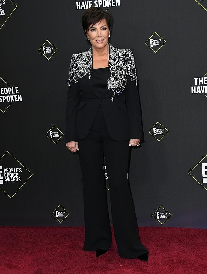 Kris Jenner escogió un traje de chaqueta con apliques de brillantes en los hombros y pantalón flare negro.