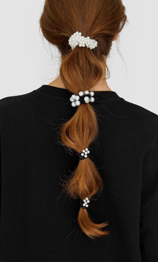 Entre nuestros favoritos está este original set de cuatro gomas de pelo con perlas que quedan perfectas juntas y por separado. Lo puedes encontrar en Stradivarius por 5,99 euros.