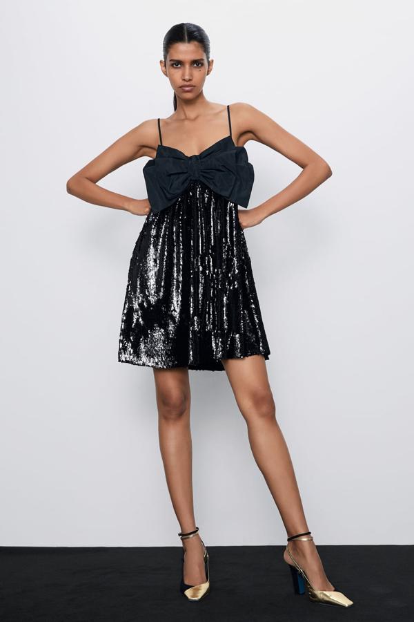 Vestido de lentejuelas negro con lazo en el pecho de Zara (39,95 euros).