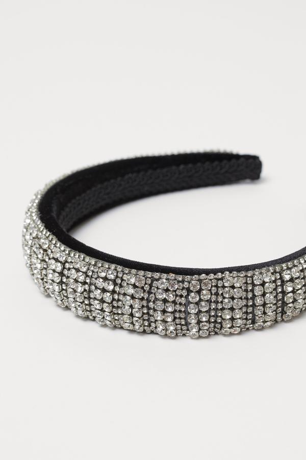 Con terciopelo acolchado cubierto por una cinta de piedras de strass, esta diadema solo está disponible en la web de H&M y cuesta 14,99 euros.
