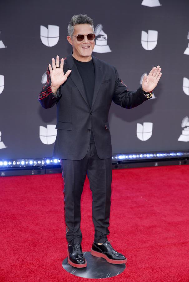 Alejandro Sanz con traje negro con adornos rojos a juego con los zapatos.