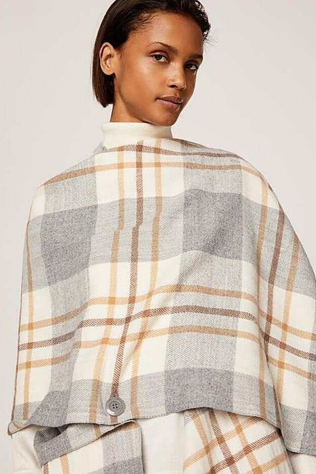 El poncho de Oysho lleva botones repartidos por toda la prenda para que se pueda colocar en diferentes posiciones.