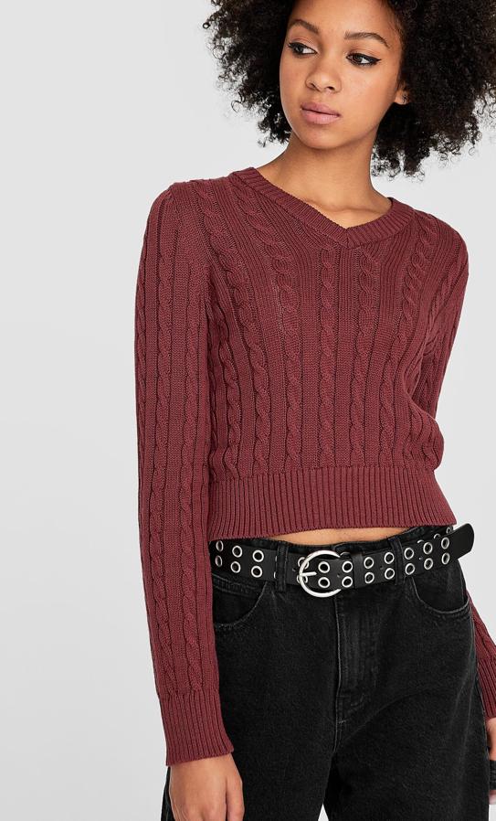 Diseño cropped y dibujo trenzado para este jersey de Stradivarius disponible en cuatro colores, piedra, vainilla, turquesa y morado (el de la imagen) costaba 17,99 euros y ahora tiene un precio de 12, 99 euros
