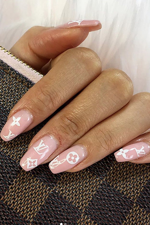 Una versión blanca sobre esmalte rosa del logo de Louis Vuitton.