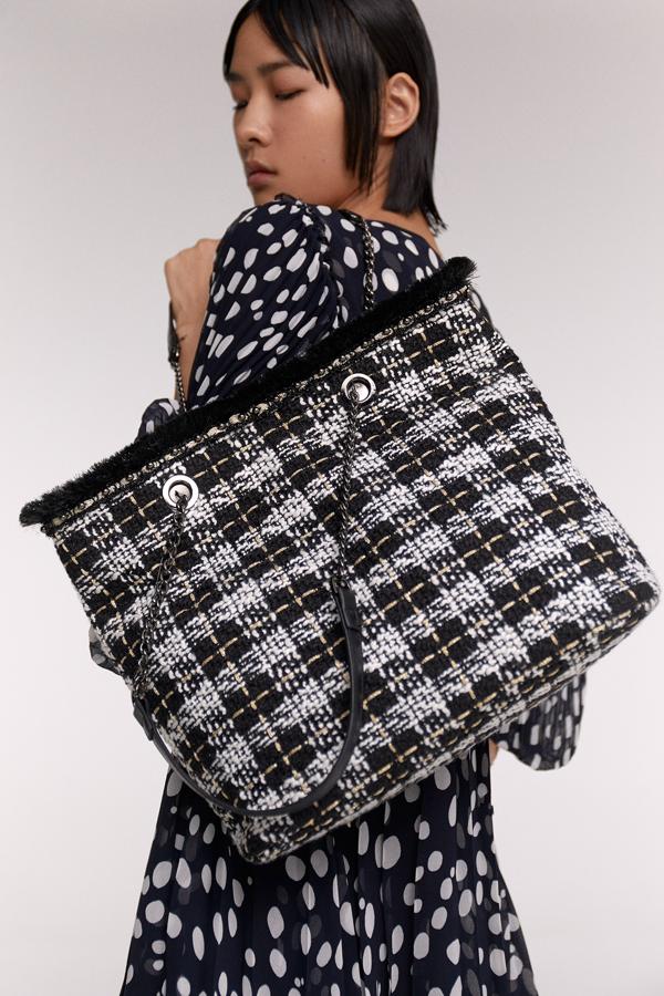 Con doble asa de cadena terminada en piel, este shopper de tweed de Sfera se suma a la tendencia otoñal con estilo y en los colores más básicos, el blanco y el negro. Cuesta 17,99 euros.