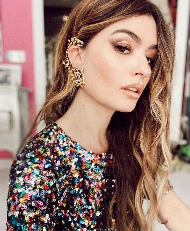 El dorado será un año más el protagonista de esta temporada de fiestas y por eso, esta opción nos ha convencido por completo. Una mirada dorada con este tipo de sombra y eyeliner geométrico, que atraerá todas las miradas. Para los labios te recomendamos que te decantes por un labial nude como el que ha elegido Madame de Rosa.