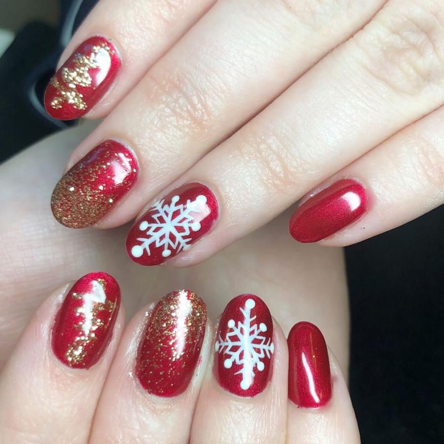 Sobre fondo de rojo brillante, copos de nieve y brillos para un look ideal para tus citas navideñas más importantes.
