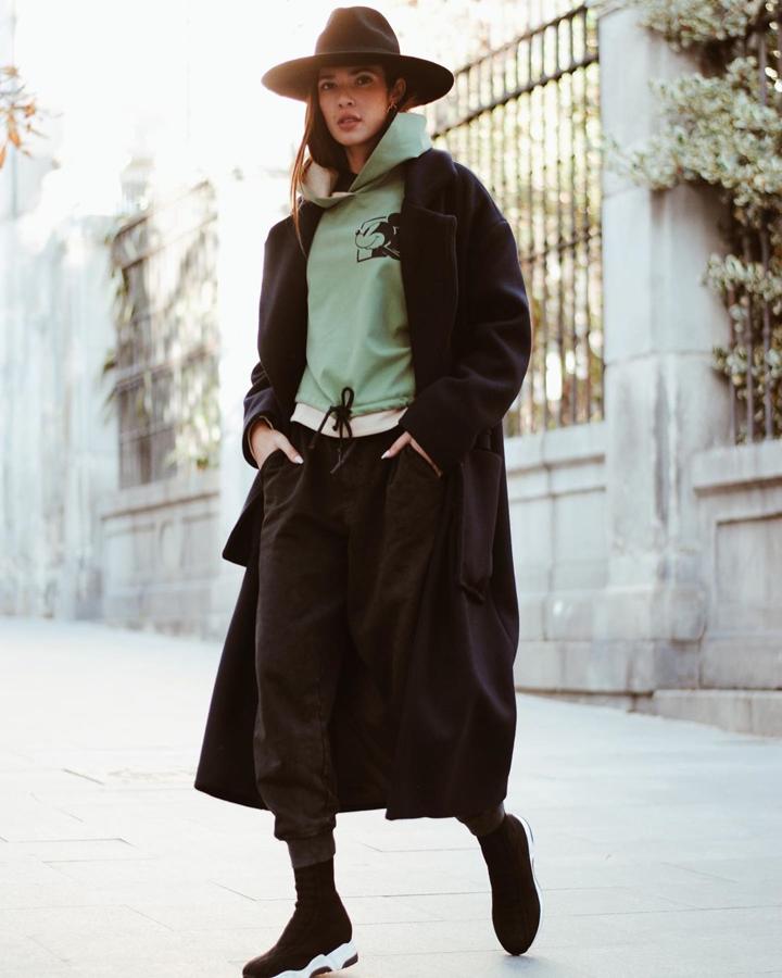 Ana Moya combinó una sudadera de Zara de Mickey con un abrigo largo negro y pantalón de chándal a juego.