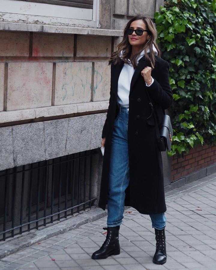Silvia Zamora combinó una sudadera blanca con un abrigo largo negro y jeans de Pinko y botines militares.