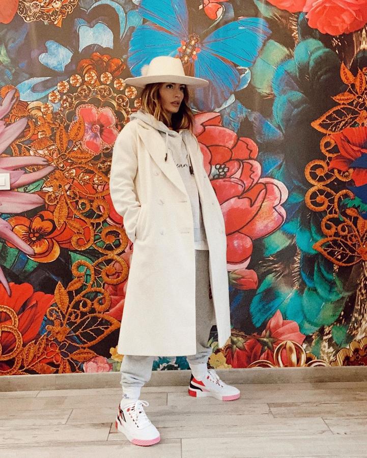 Ángela Rozas optó por un look comfy con una sudadera gris a juego con el pantalón de chándal que combinó con un abrigo blanco y sombrero de la colección de Dulceida para Primak.