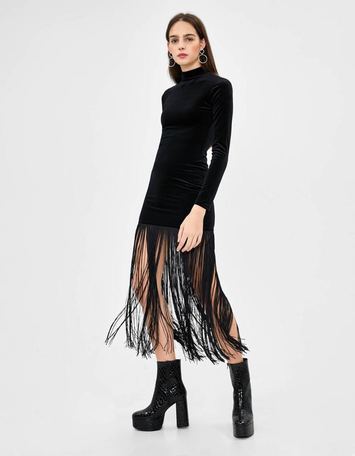 Vestido negro de terciopelo y cuello alto con flecos en el bajo de Bershka (29,99 euros).