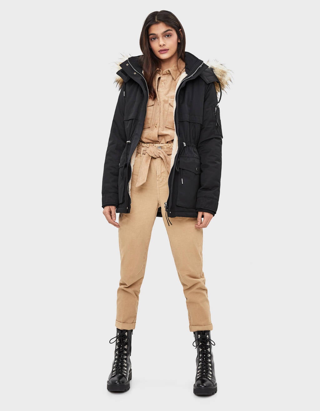 Parka negra con capucha de pelo y forro de borreguito interior. (59,99 euros). De Bershka.