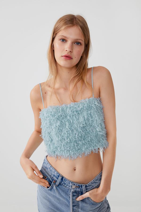 En azul claro, este top cropped de escote recto y tirantes finos con efecto pluma cuesta 22,95 euros. Está disponible en cuatro tallas, de la XS a la L, en Zara.