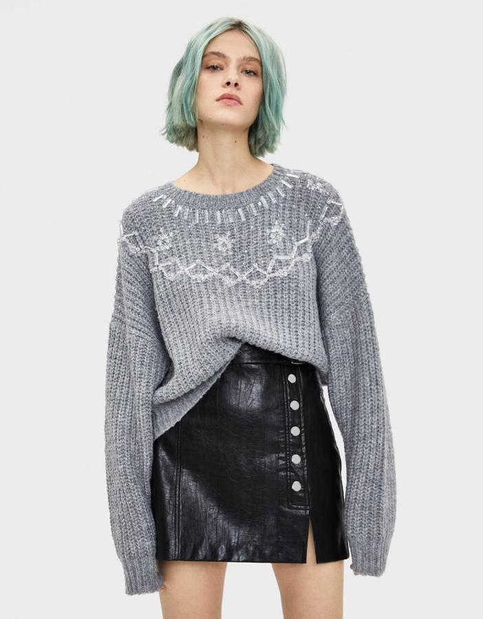 En la última colección de Bershka podemos encontrar este jersey con abalorios aplicados en dibujo, también en color gris. Cuesta 35,99 euros y la talla L se está agotando.