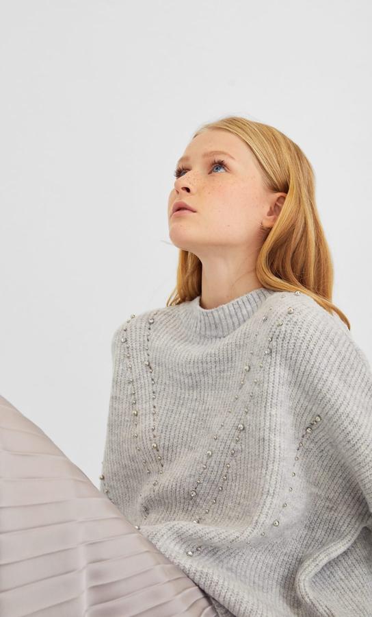 En crudo, gris marengo y gris claro Stradivarius tiene este jersey oversized con detalles de apliques billantes en el frontal. Cuesta 25,99 euros.