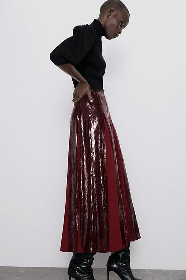 La falda tiene el tiro alto y es ideal para llevar con unas botas negras de tacón.