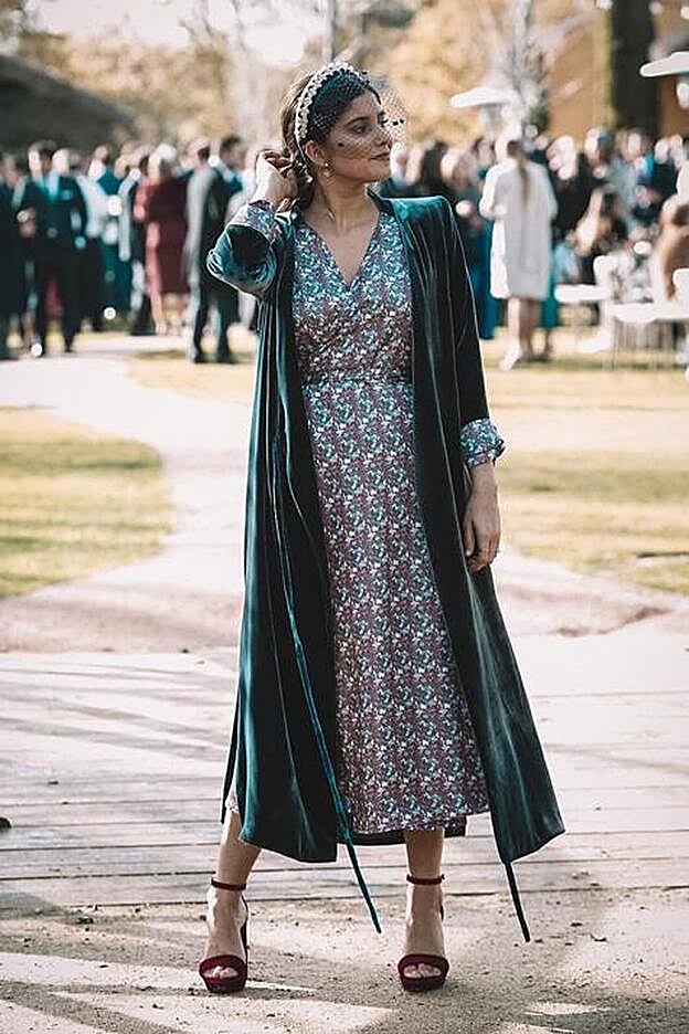 La influencer apostó por un look de invitada invernal con un vestido estampado y un abrigo de terciopelo.