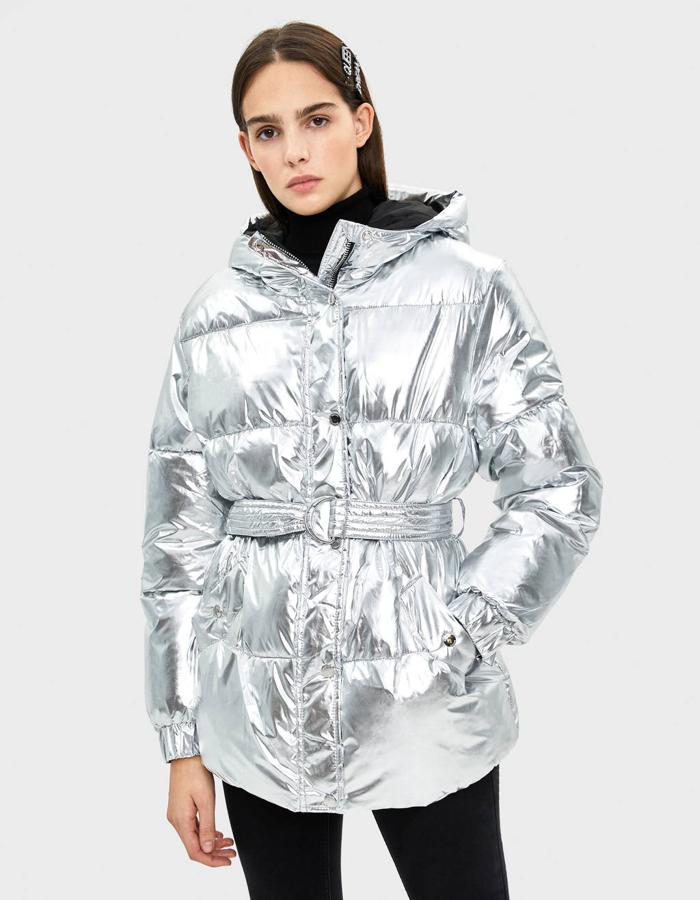 Cazadora puffy metalizada con cinturón de Bershka (45,99 euros).