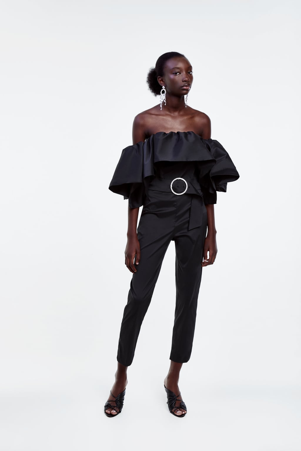 Uno de los best seller de Zara que todavía puedes conseguir: mono de palabra de honor con volantes y cinturón. (89,95 euros).