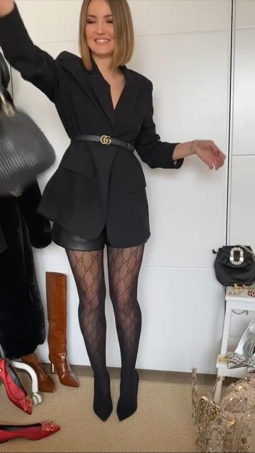 Alexandra Pereira con short efecto piel, body de encaje, blazer negra a modo de vestido de Asos (59 euros), medias de Gucci y unos stilettos negros.