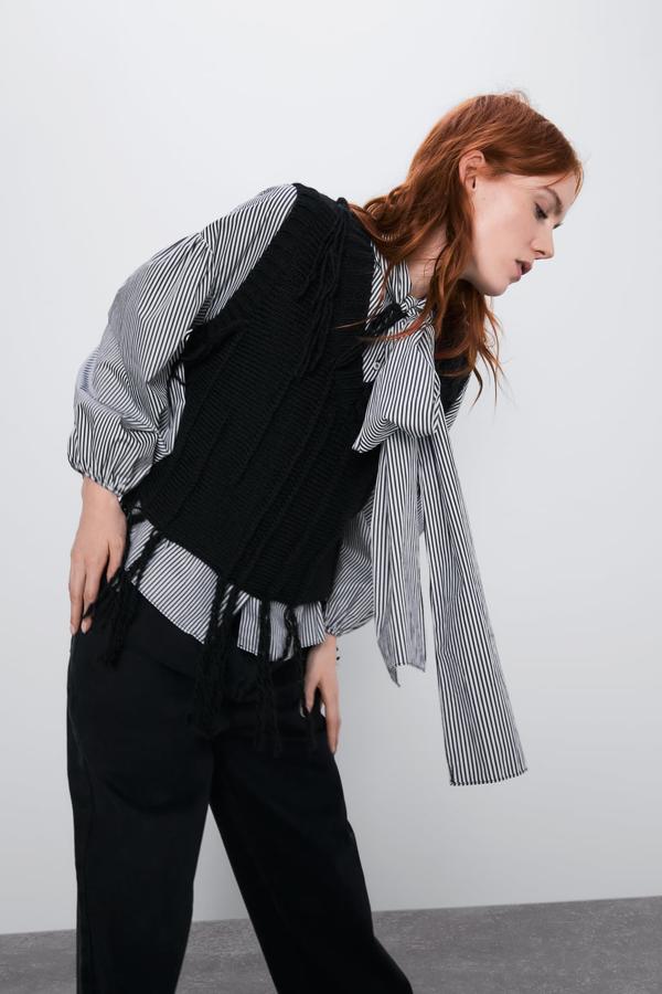 chaleco de punto negro con flecos en el bajo de Zara (19,95 euros).