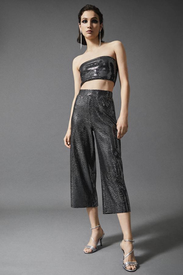 Lo mejor de la colección de Lefties para la última noche del año es que no solo está cargada de vestidos, también de conjuntos igual o más interesantes. Este de pantalón y top bandeu es uno de nuestros favoritos. Eso sí, no es apto para pasarse con e turrón en la cena. El pantalón cuesta 15,99 y el top, 7,99 euros.