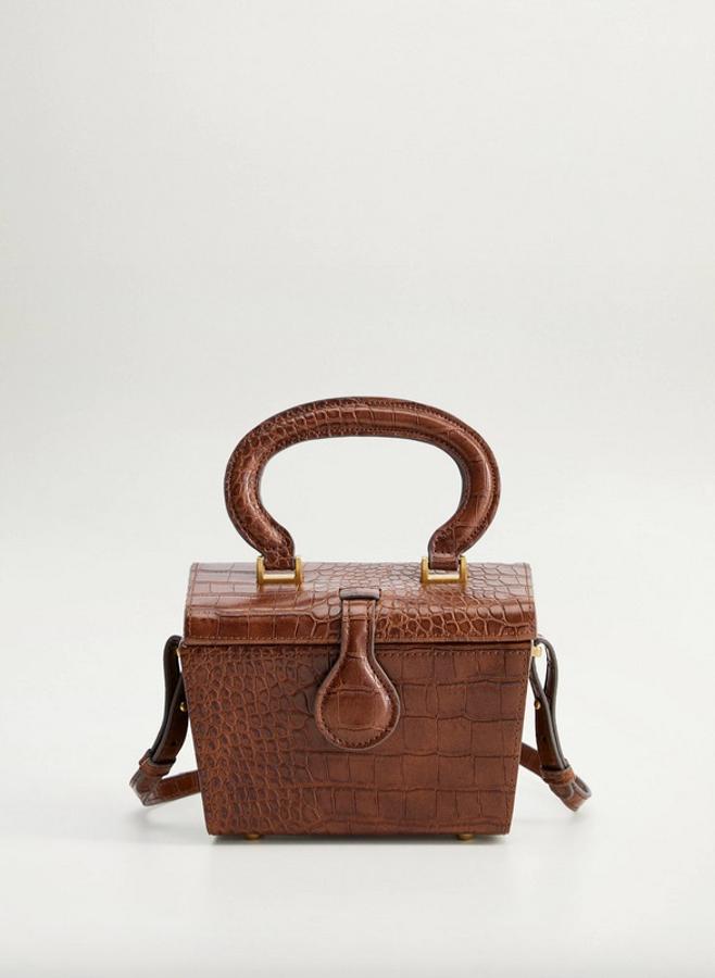 El contrapunto a la tradicional bandolera negra de efecto cocodrilo es este bolso cofre de Mango que sigue apostando por el animal print, pero en esta ocasión lo hace en color marrón y con una original forma de cofre. Con asa corta y larga para llevarlo como mejor se preste la ocasión, tiene un precio de 39,99 euros.