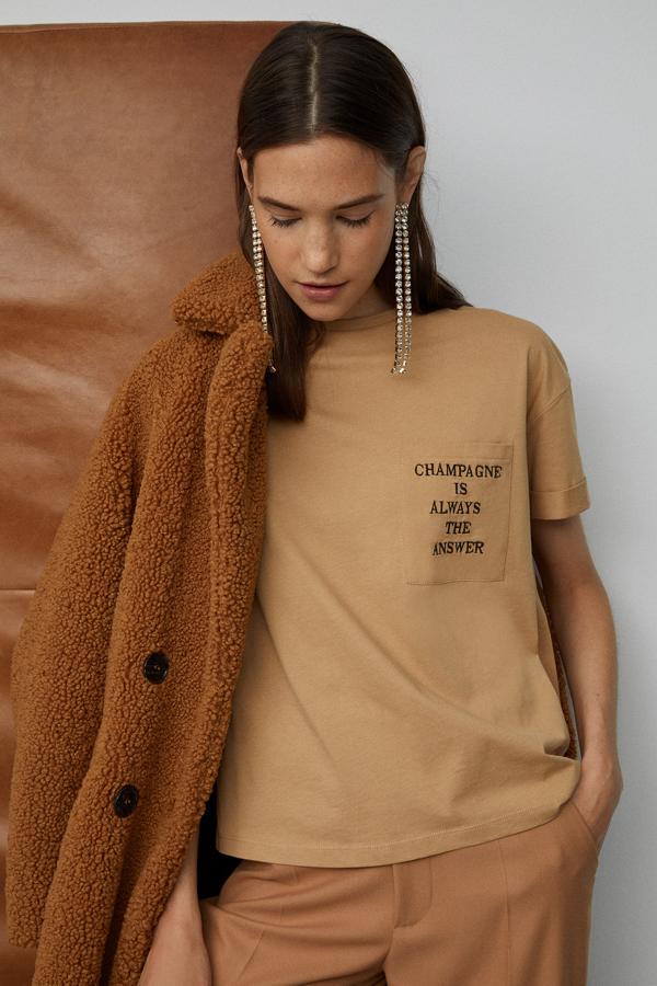 Una camiseta con mensaje siempre es un buen regalo, y más si se sale de los tonos habituales. Esta de Sfera cuesta 9,99 euros, tiene bolsillo con el mensaje en la parte izquierda y un color café perfecto para unos jeans o cualquier look de oficina. También está disponible en azul con letras blancas.