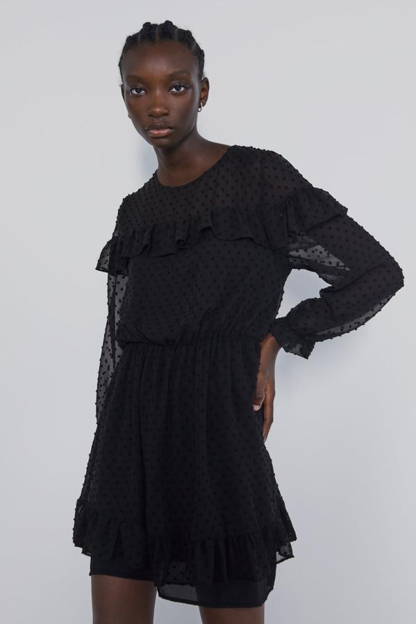 Está casi a mitad de precio y seguro que las pocas tallas que quedan se agotan rápido, pero todavía podemos regalar un socorrido vestido corto negro. En este caso viene con cuello redondo y volantes combinados a tono en tejido con lunares. Es de Zara y cuesta 15,99 euros.