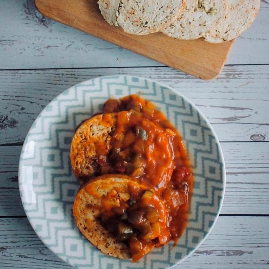 Ingredientes:3 pechugas de pollo 1 kg 200-300 gr)1 manzanaUna pizca de salEspecias: comino, pimienta, ajo en polvo, perejil y pimentónPreparación:- Limpia las pechugas y córtalas en dados para picarlas mucho.- Pela y ralla la manzana.- Mezcla las especias con el pollo y estira la mezcla sobre un film transparente. Haz una serie de surcos para meter ahí la manzana. Pliega el rollo sobre sí mismo y empaqueta como un caramelo, consiguiendo un cilindro bien prieto y compacto. Si no te ves capaz, usa otro trozo de film para reforzarlo y que no te entre agua al cocerlo.- Lleva una olla con agua a hervor suave que cubra el rollo 2/3 de su tamaño. Hierve durante 35-40 minutos, dándole la vuelta al rollo a mitad del tiempo.- Dejar enfriar y reposar 6-7 horas en nevera para poder cortar fino.- Los rellenos pueden ser de todo tipo, como pasas y piña. Pero ten cuidado en separar los trozos de lo que le pongas, o se te romperá al intentar cortarlo.- Consejo: puedes sacarlo del film cuando esté templado y marcarlo en la sartén para que haga una costra por fuera..