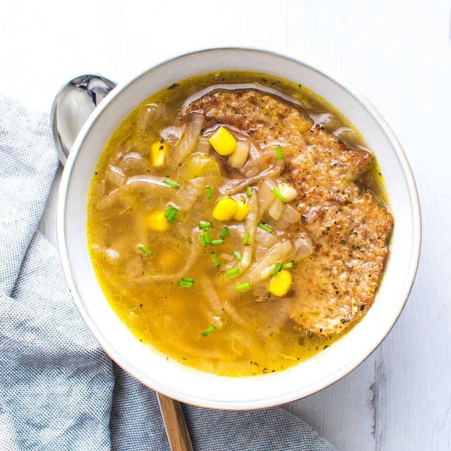 Ingredientes (2 raciones):300 gr de cebolla dulce70 gr de maíz600 ml de caldo de verduras caseroPan integral 100%AOVECebollinoAlbahacaOréganoAjo en polvoUna pizca de sal Ingredientes para 1L de caldo de verduras:250 gr col140 gr nabo160 gr zanahoria70 gr puerro40 gr chirivía40 gr apio1L aguaAOVESalPreparación:- Para el caldo: En una olla con un chorrito de aceite rehogar ligeramente la verdura, añadir el agua, sazonar y cuando rompa a hervir cocer a fuego medio-bajo durante 45 min-1 h. Colar y reservar.- En otra olla con un chorro de aceite rehogar la cebolla previamente cortada en juliana a fuego bajo.- Añadir el maíz y saltear junto con la cebolla unos minutos.- Incorporar el caldo de verduras y dejar cociendo a fuego medio-bajo 30 min. Sazonar al gusto.- En una sartén engrasada, tostar las rebanadas de pan con orégano, albahaca y ajo en polvo.- Emplatar la sopa, añadir el pan para que se empape y espolvorear cebollino picado.