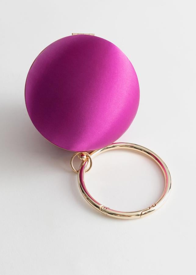 En & Other Storie nos han sorprendido con este bolso en forma de cilindro de raso fucsia y asa rígida dorada. Con el descuento se ha quedado en 28 euros (antes costaba 69).