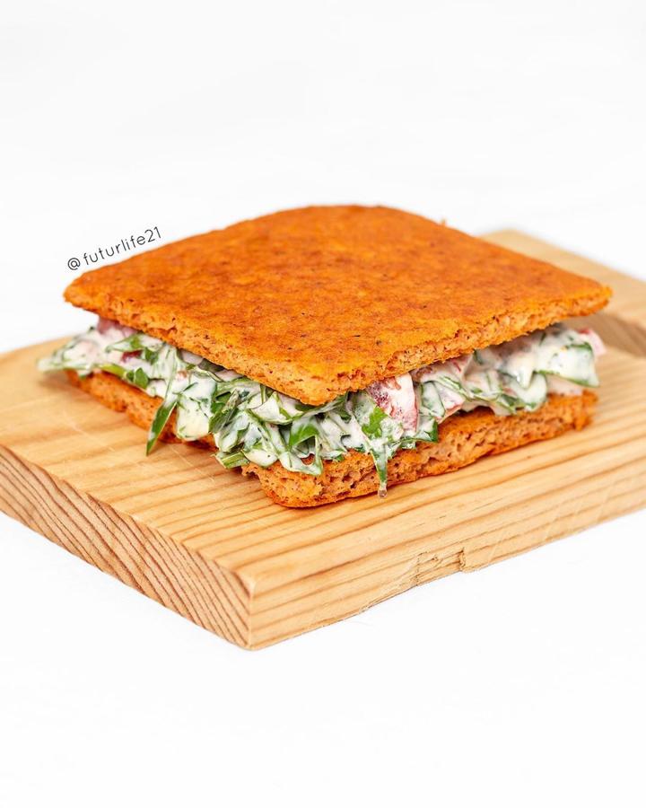 Ingredientes:200g de pollo de hacer caldo100g de tomate frito futur4 huevos ecológicosOré́ganoPimientaSalOpcional:2Cs de harina de espelta integral o de quinoa1/2 sobre de levadura royalPreparación:-Calentar el horno a 180°C arriba y abajo.-Poner en un vaso de batidora el pollo, el tomate y añadir los huevos, la levadura (opcional), la harina de espelta (opcional), un poco de sal y el orégano hasta convertir en una masa homogénea.-Extender sobre un papel de horno aceitado, ayudándonos con una espátula para darle forma rectangular si vas a preparar un sandwich o forma redonda si va a ser base de pizza.-Introducir en el horno precalentado unos 10-15 min. Dar la vuelta y dejar otros 5 min.-Sacar, cortar en el tamaño deseado y reservar. Si se va a preparar una pizza poner los toppings y meter al horno de nuevo para terminar la pizza.-Se puede congelar.Presentación:Dependiendo de para que vayas a utilizar el pan de pollo con tomate, puedes hacer sandwich, panecillos o pizza.