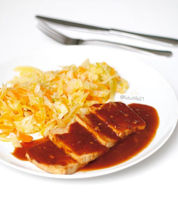 Ingredientes:Tofu3-4 Cs deSalsa de soja2Cs de AOVE1 diente de ajo1Cs de harina de espelta integral o de harina de quinoaPara el acompañamiento:RepolloZanahoriaCebollaAOVEPreparación:-Cortar el tofu en filetes de 1 cm de ancho. Mezclar la salsa de soja con el AOVE y el ajo picadito. Macerar el tofu en esta salsita 10 minutos. En una sartén hacer el tofu a la plancha, reservar.-A la salsa donde se ha macerado el tofu añadirle 1 Cs de harina de espelta o harina de quinoa. Mover bien hasta que se disuelva la harina y no queden grumos. Añadir 100-200ml de agua y remover. Verter en la sartén donde hemos hecho el tofu anteriormente. En un minuto veremos como se espesa la salsa. Verter la salsa sobre el tofu hecho previamente.-Para el acompañamiento pocha toda la verdura (Repollo, zanahoria, cebolla) en AOVE.