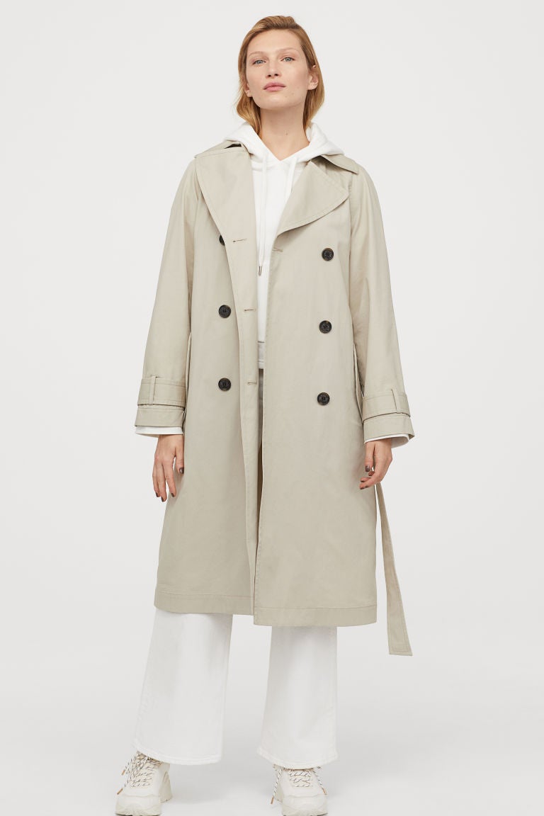 Trench de algodón beige claro de doble botonadura con cinturón de anudar extraíble. Encuéntralo en las rebajas de H&M por 44,99 euros. Antes: 59,99 euros.